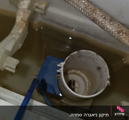 תמונה של פנים מיכל אסלה עם צינור ומים